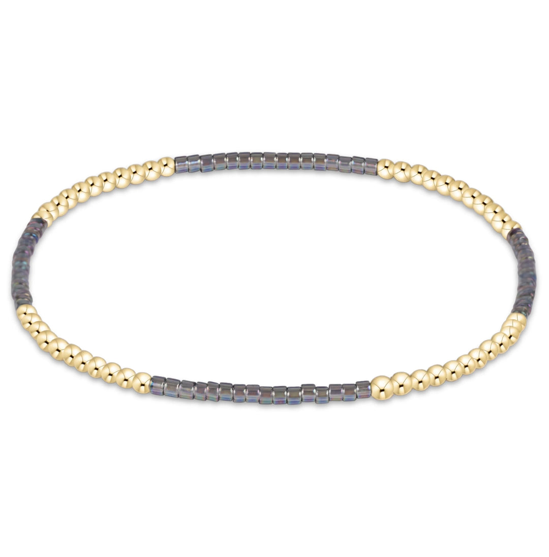 GOLD AND GRAY BEADED BRACELET ON WHITE BACKGROUND