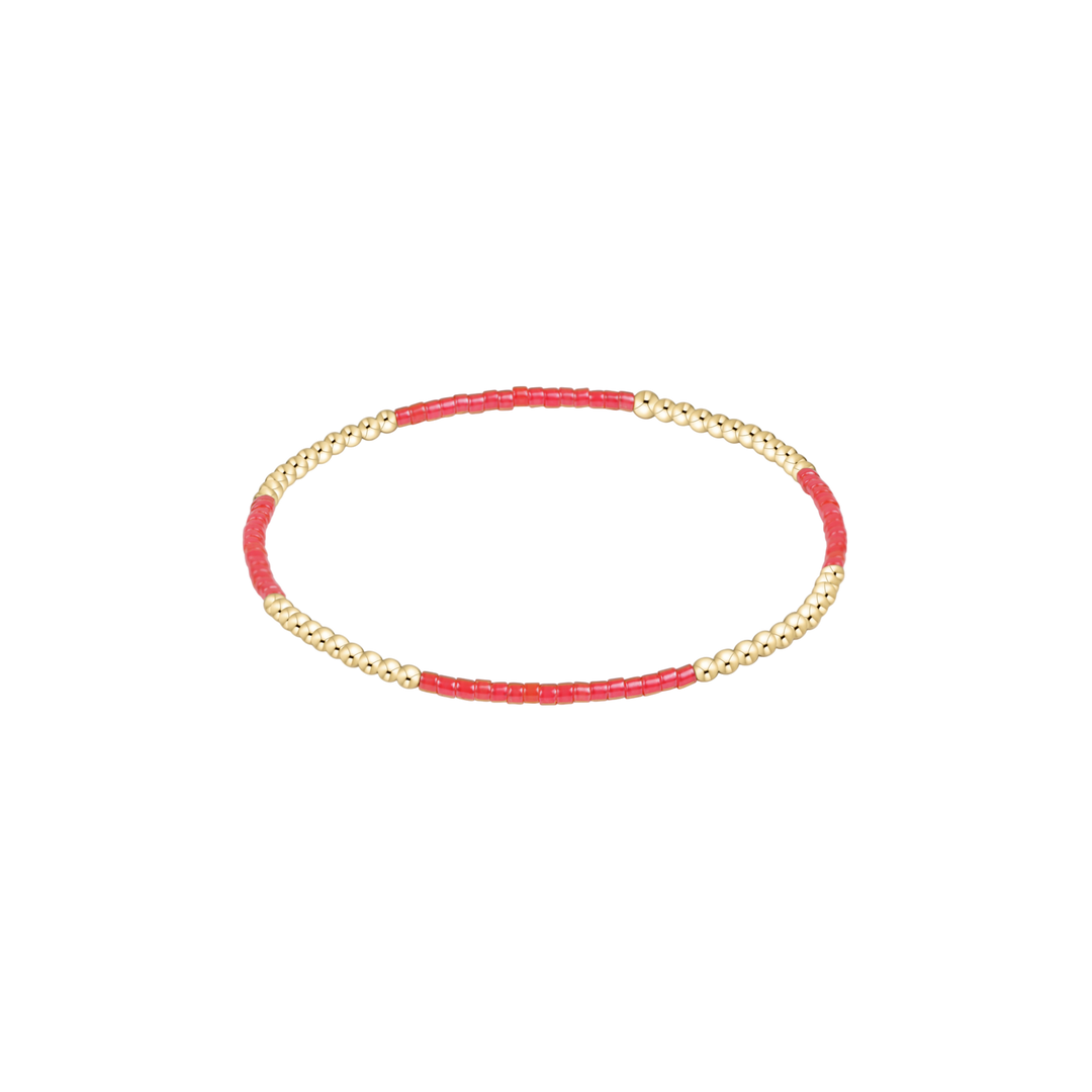 Bracelet with red beads and gold chain on a white background