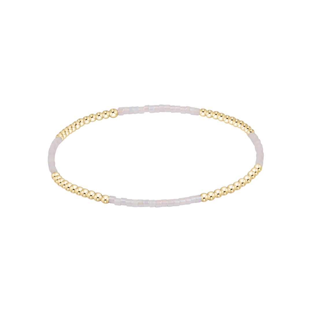 Gold and white beaded bracelet on a white background