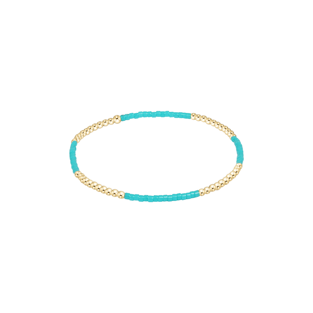 Turquoise and gold bracelet on a white background