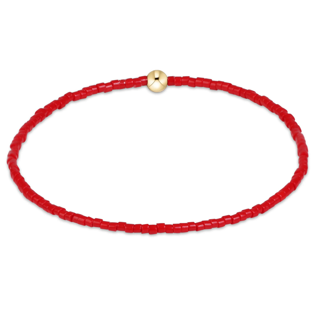 Red beaded bracelet with a gold clasp on a white background