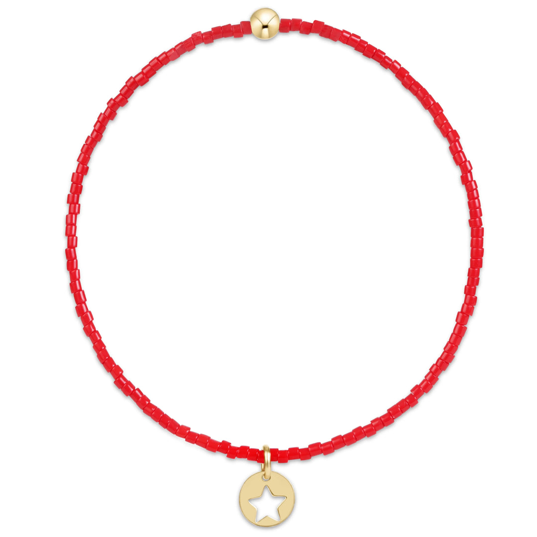 Red string bracelet with a gold star charm on a white background