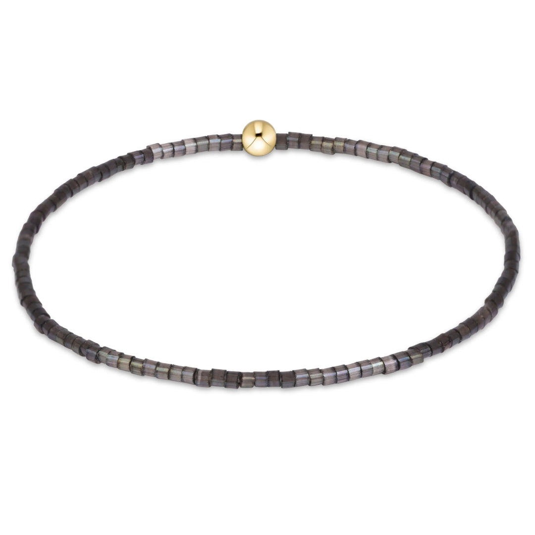 DARK GRAY AND BLACK BEADED BRACELET WITH GOLD BEAD IN MIDDLE