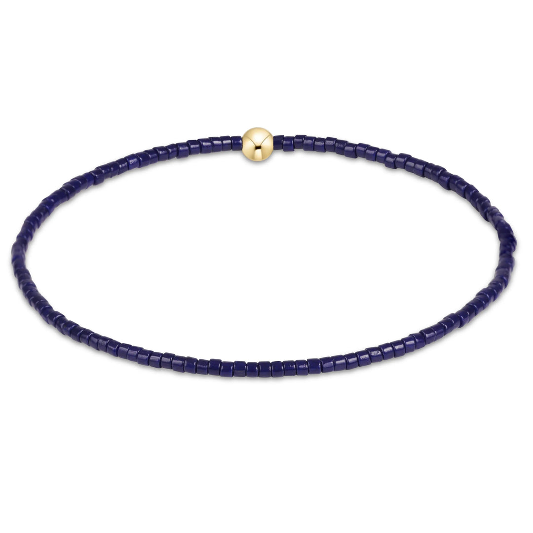 Navy blue beaded bracelet with a gold clasp on a white background