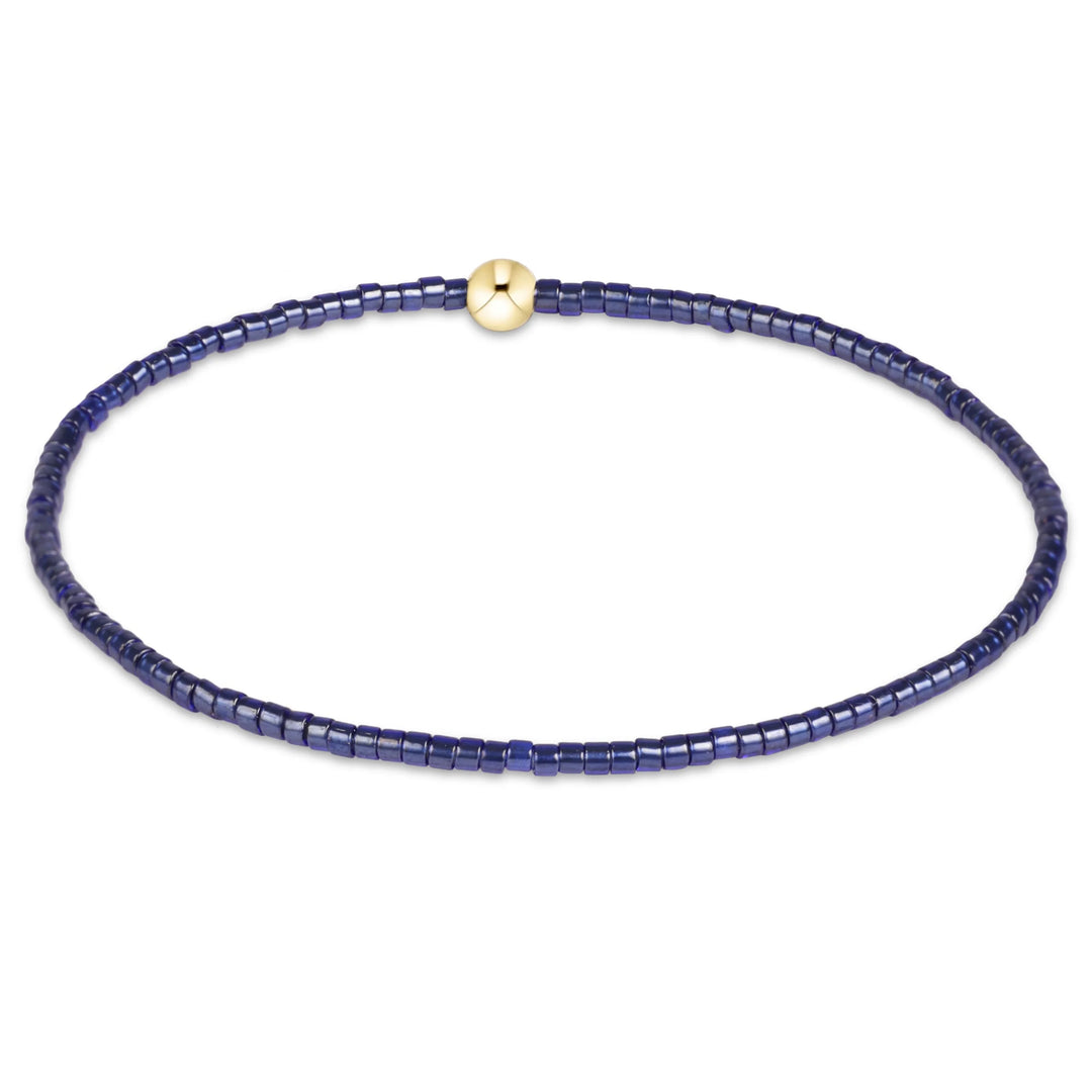 navy 2mm seed beads and a 4mm, 14kt gold-filled bead bracelet on white background