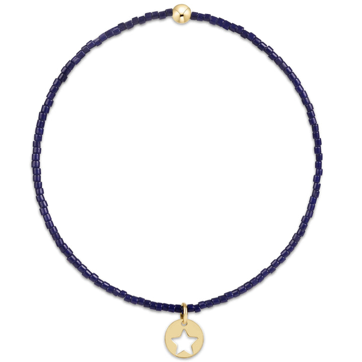 Navy blue beaded bracelet with a gold star pendant on a white background