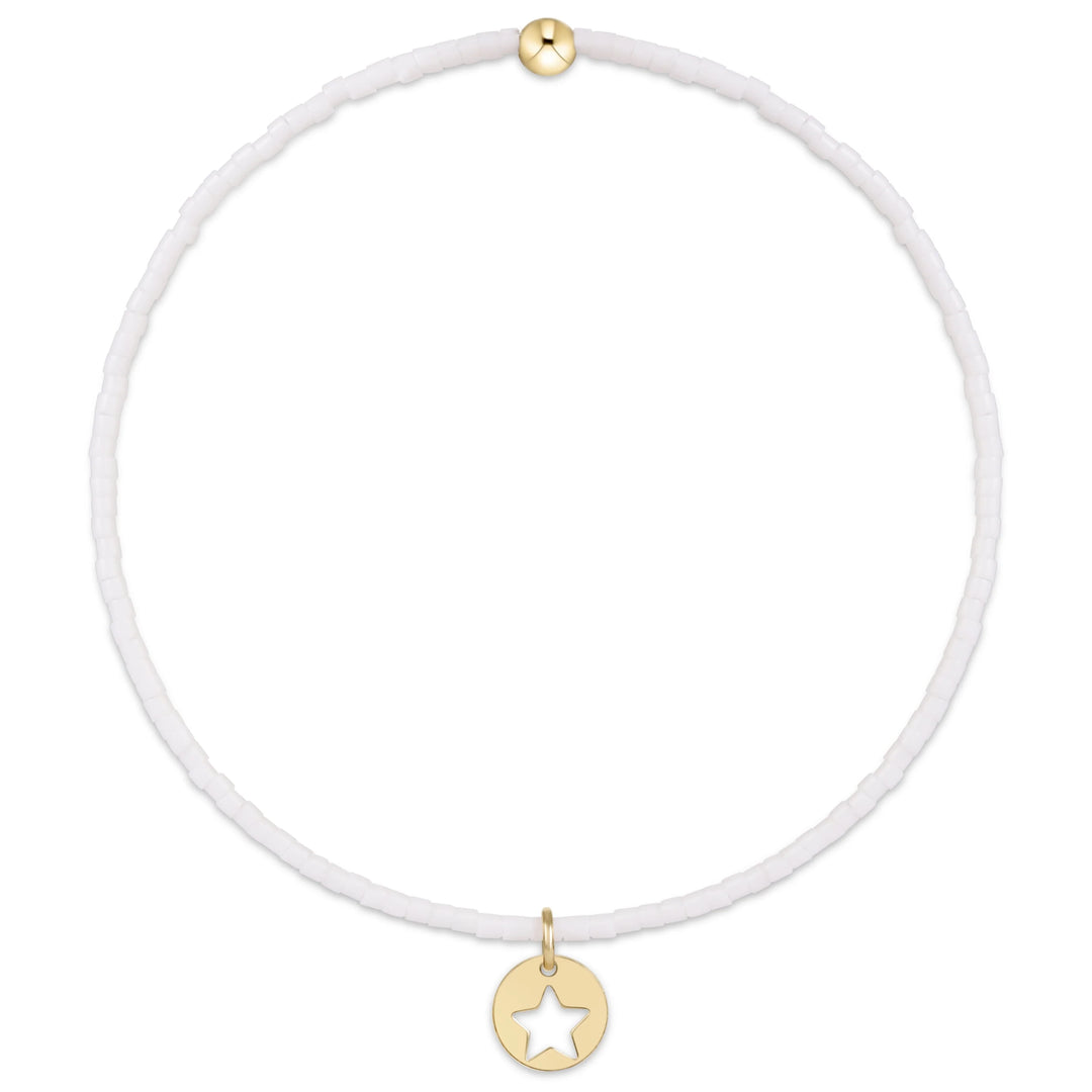 White beaded bracelet with gold star pendant on a white background