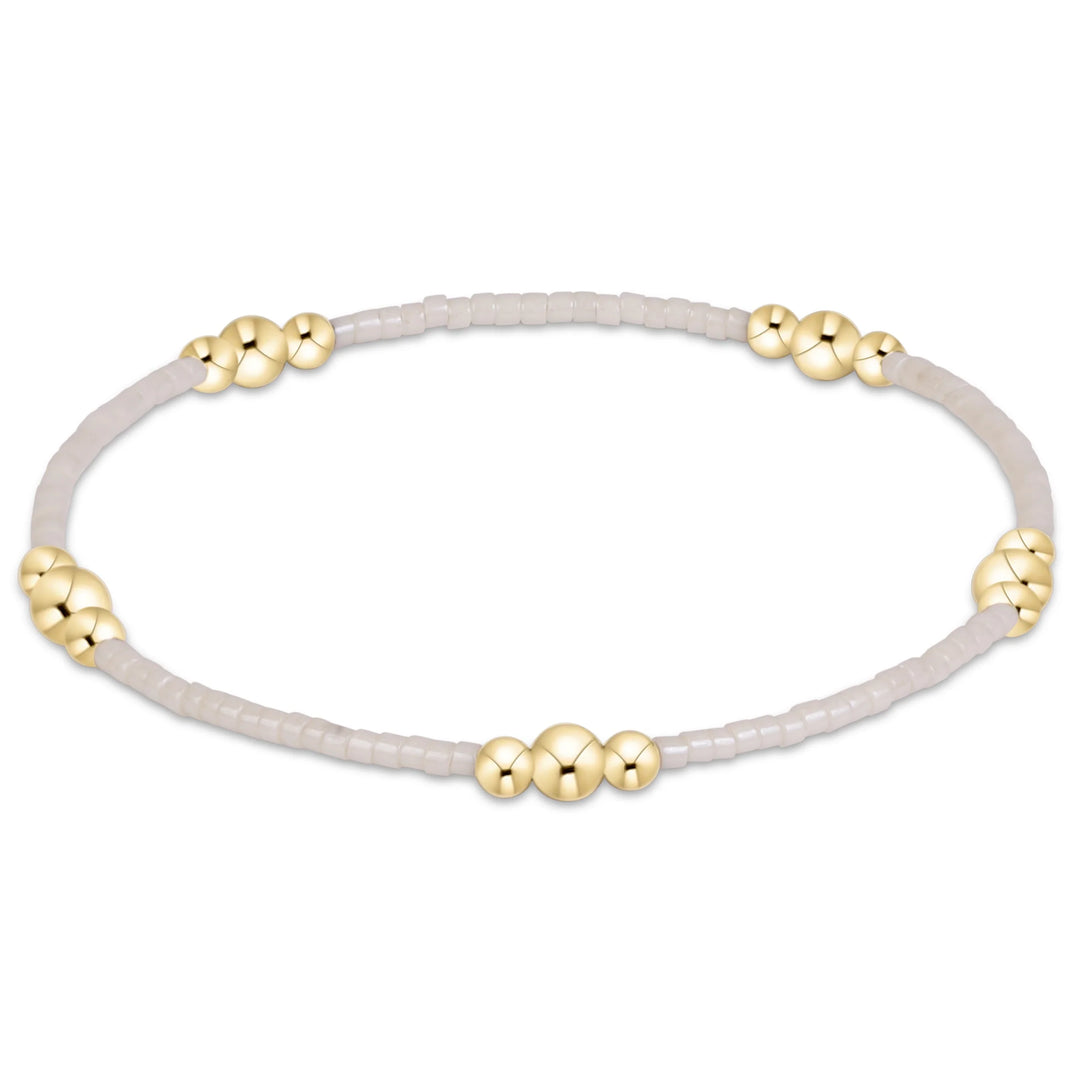 cream beaded bracelet with gold beads in clusters of three