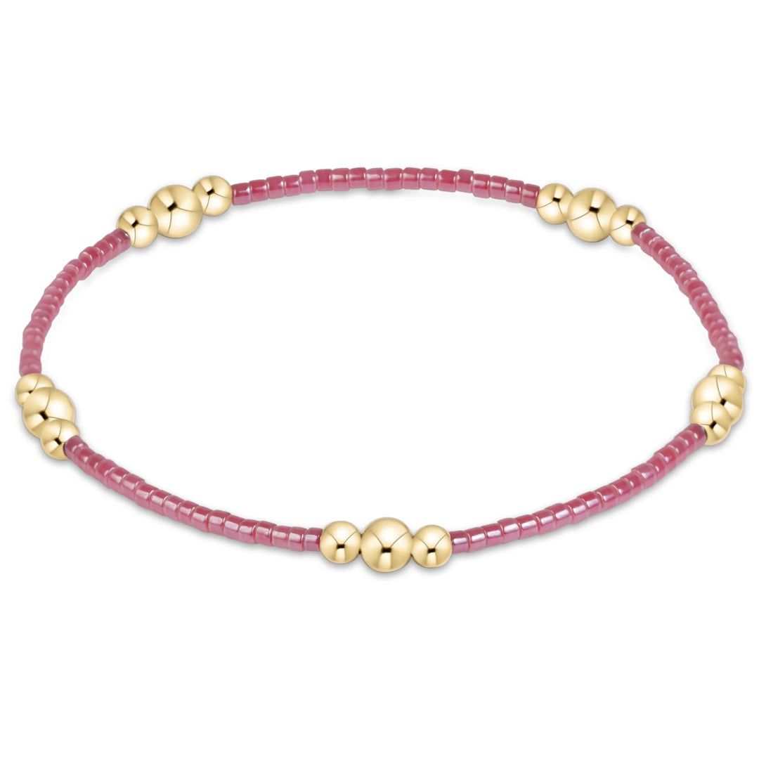 PINK BEADED BRACELET WITH GOLD CLUSTER ON WHITE BACKGROUND