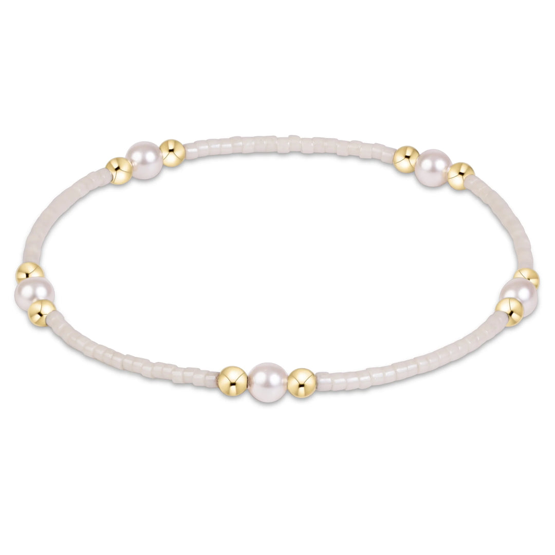 CREAM AND GOLD BEADED BRACELET WITH PEARLS ON WHITE BACKGROUND