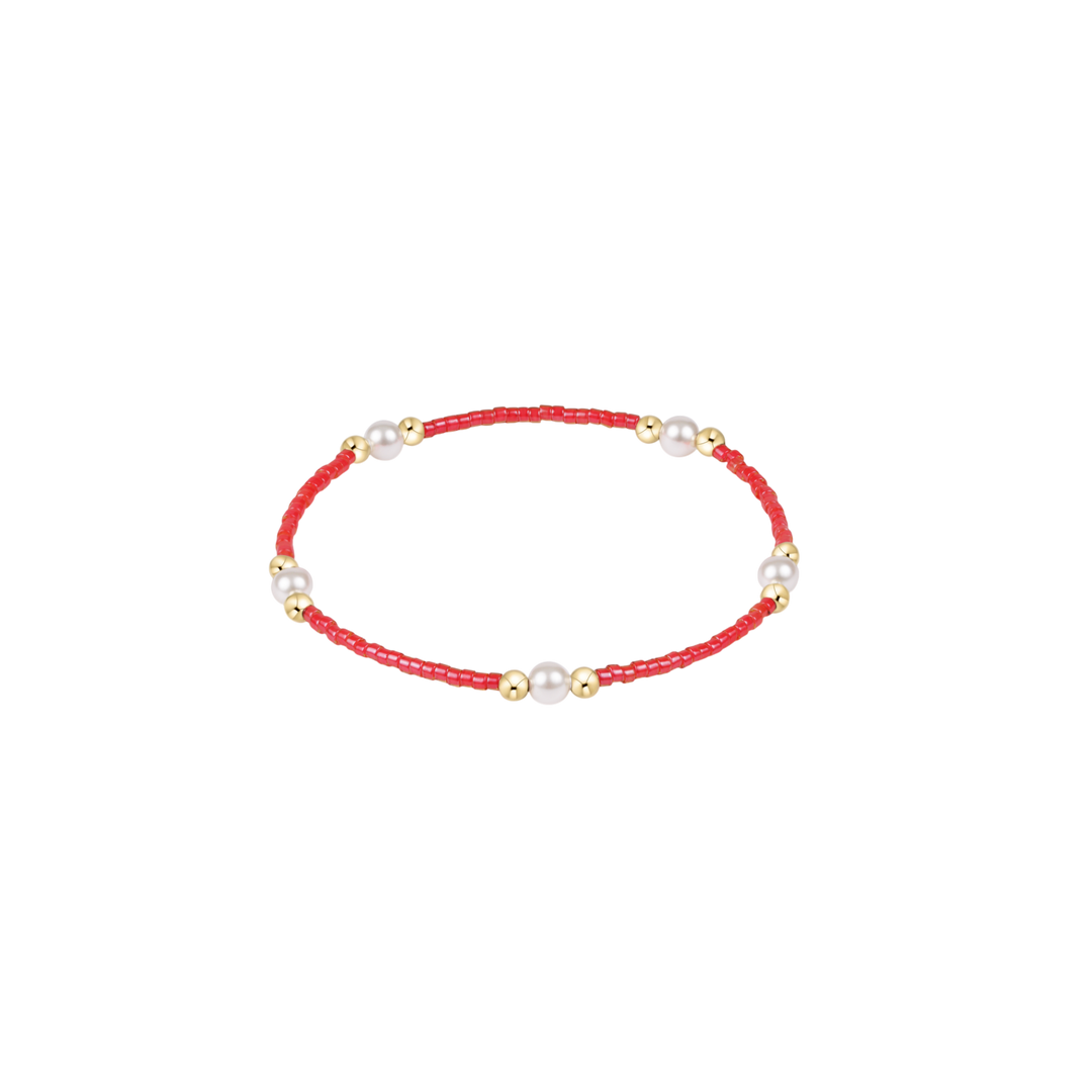 Bracelet with red cord and pearls on a white background