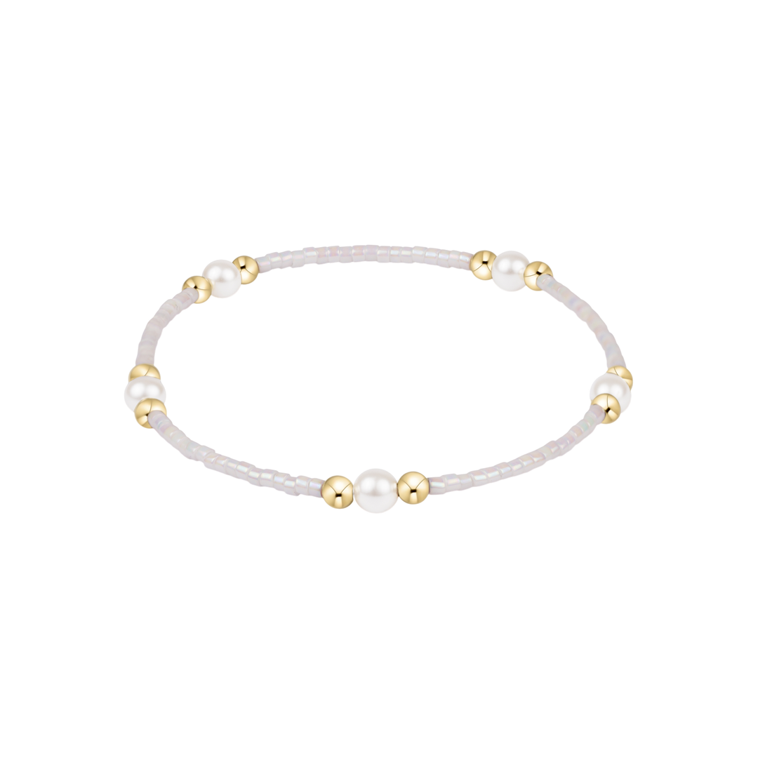 Bracelet with white beads and gold accents on a white background