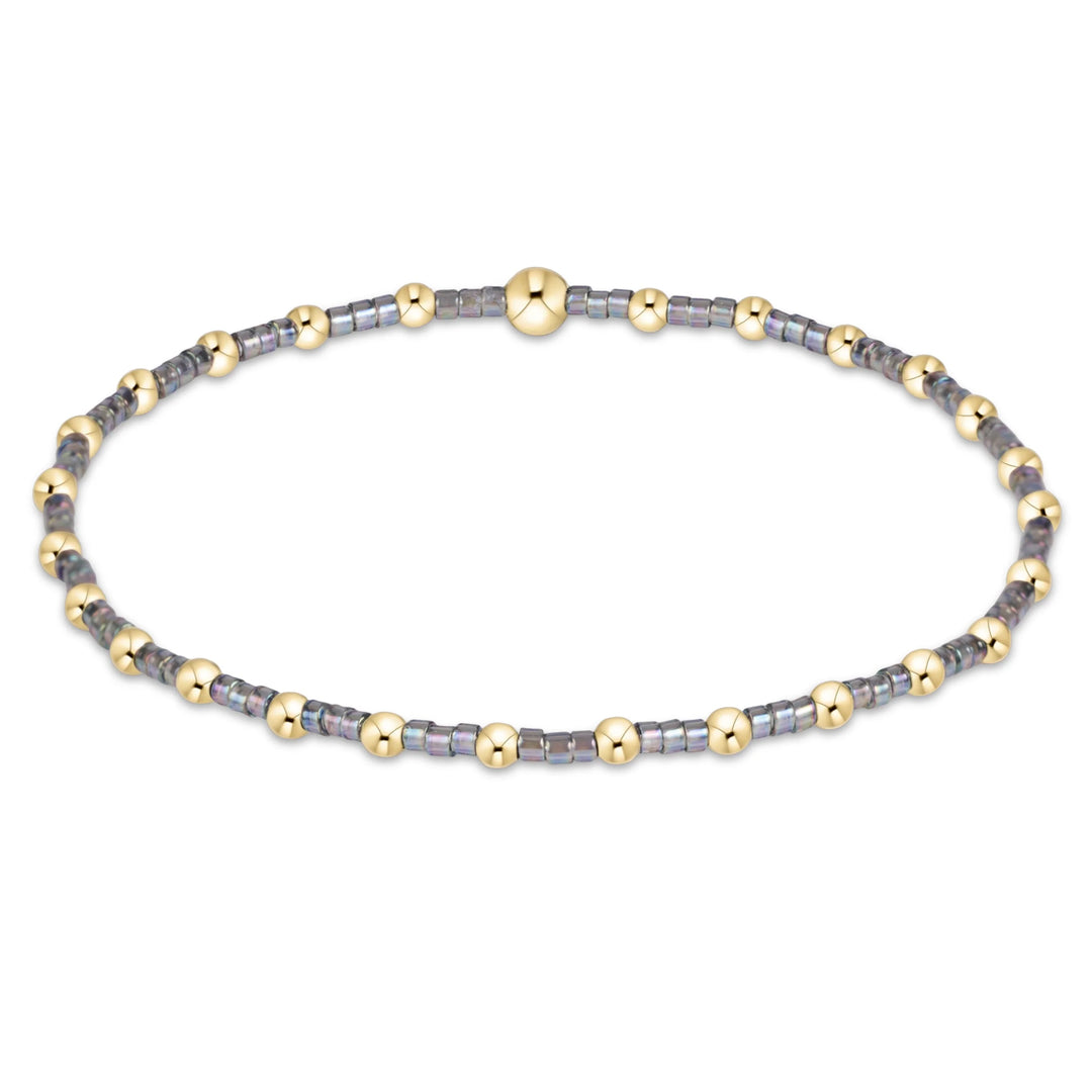 gray and gold beaded bracelet on white background