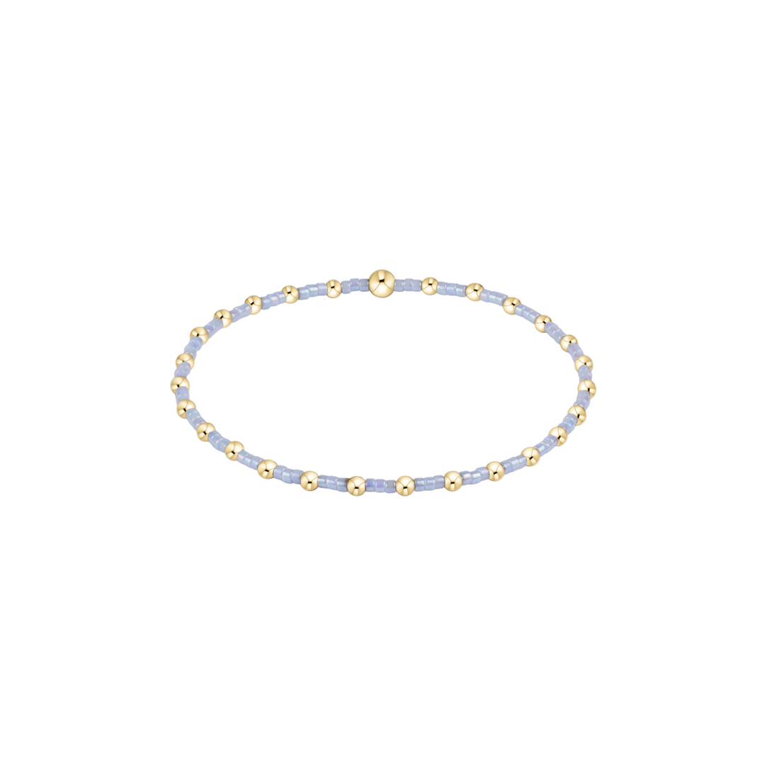 Bracelet with gold and light blue beads on a white background