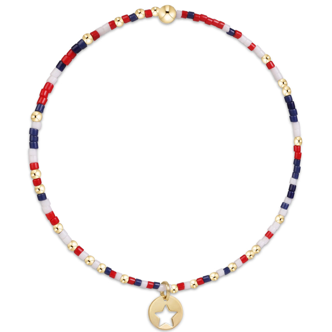 Bracelet with red, white, and blue beads and a gold star charm on a white background