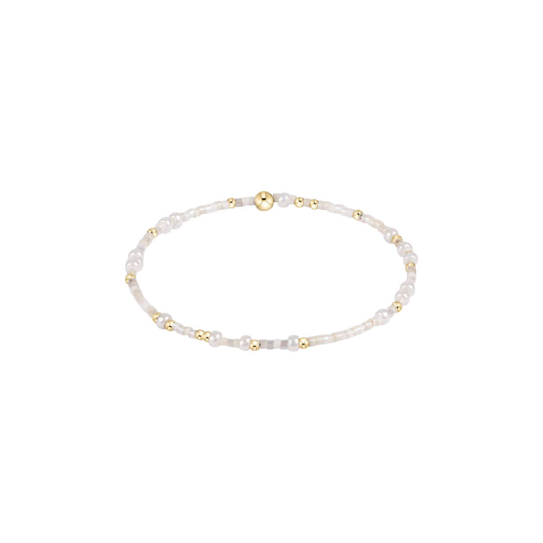 white and beige beaded bracelet with gold accents 
