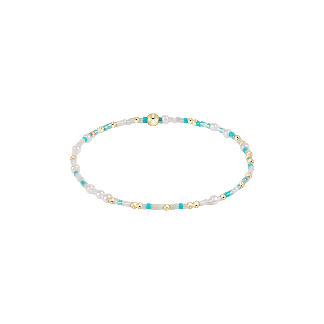 turquoise and white beaded bracelet with gold accents