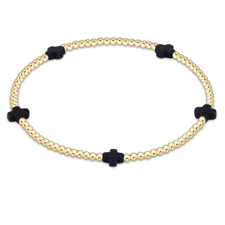Bracelet with gold beads and navy cross-shaped ends on a white background