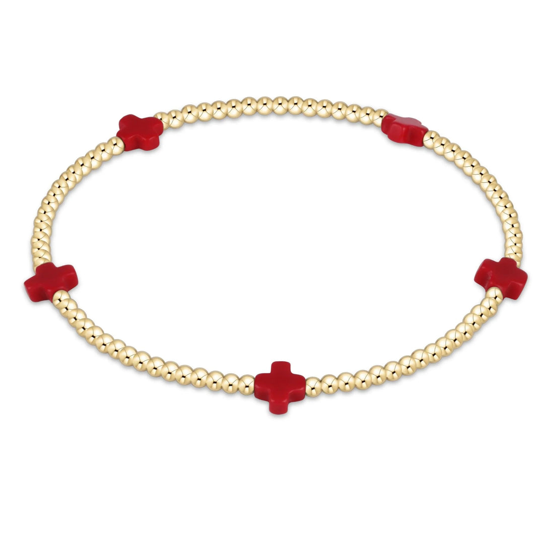 Bracelet with red cross-shaped beads on a white background