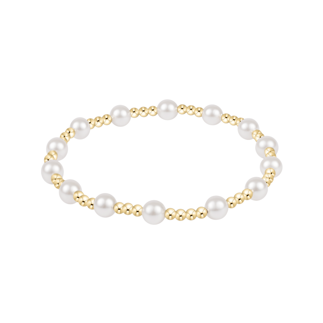Pearl and gold beaded bracelet on a white background