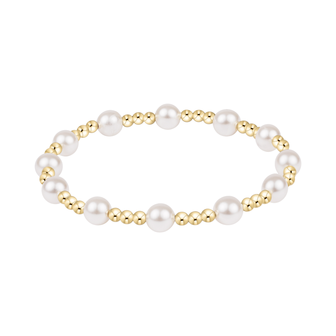 Pearl and gold beaded bracelet on a white background