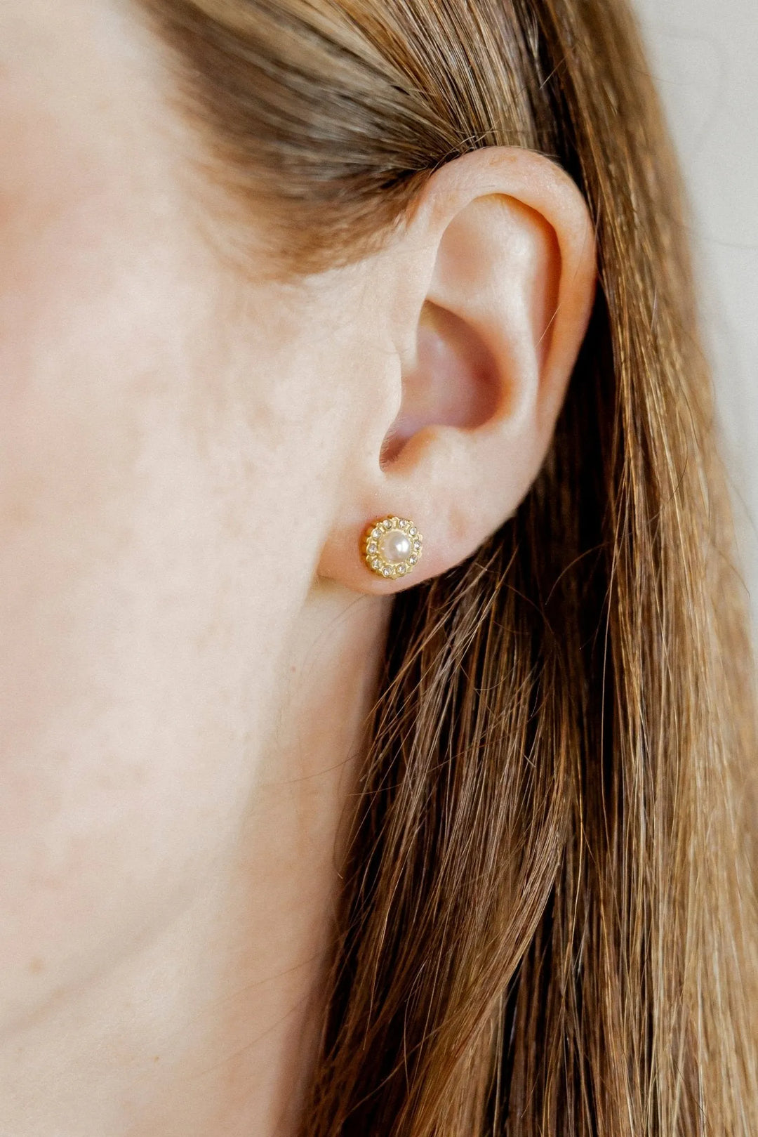 Margaret pearl and crystal halo screwback stud earring worn on the ear