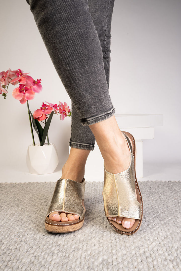 gold wedge sandal on woman's foot
