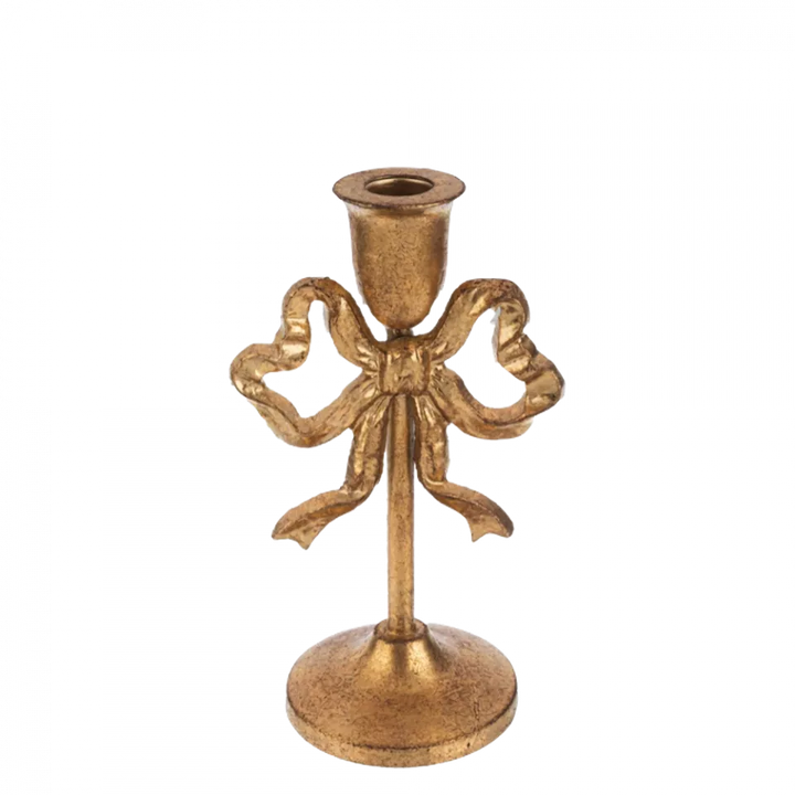 Decorative gold candle holder with bow design on a white background