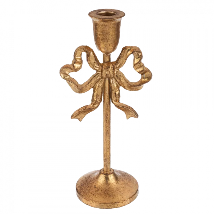 Gold candle holder with bow design on a white background