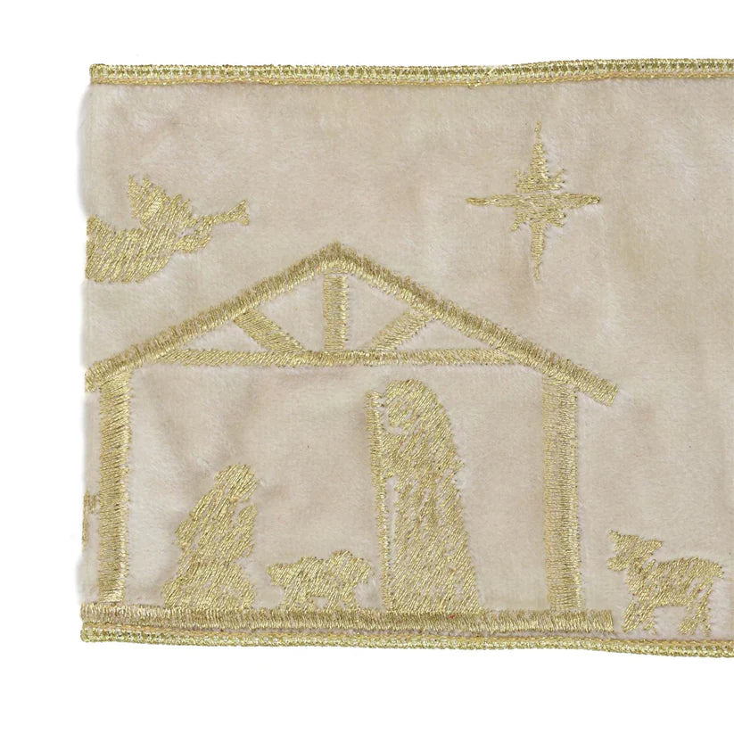 Embroidered nativity scene with stable, star, and animals on beige fabric.