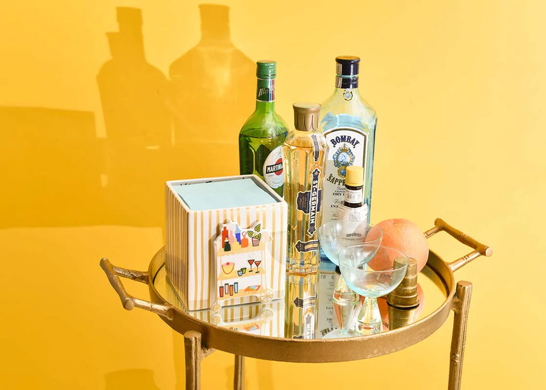 Alcohol bottles on a gold tray with a yellow background