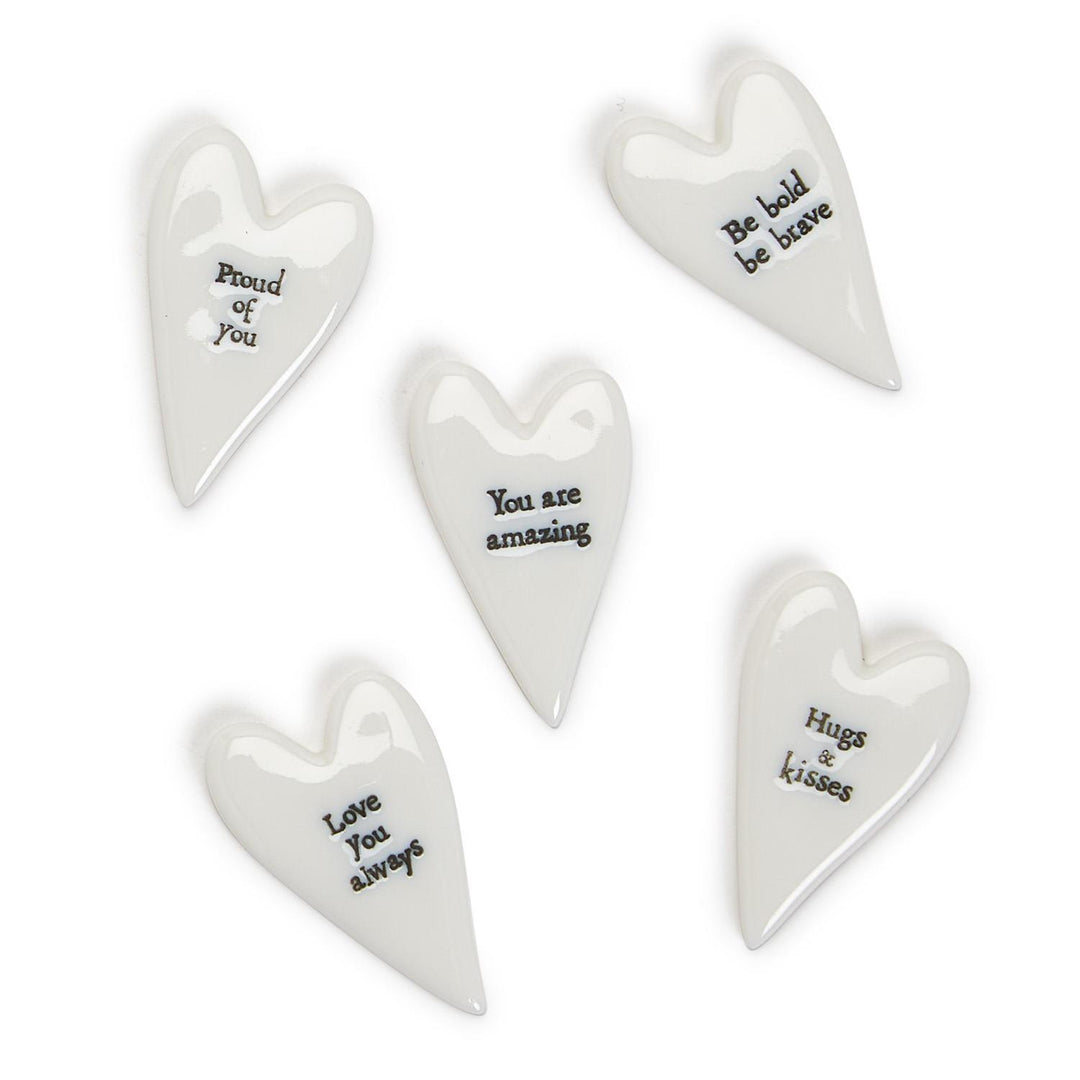 Set of five white heart-shaped ceramic plaques with motivational phrases on a white background