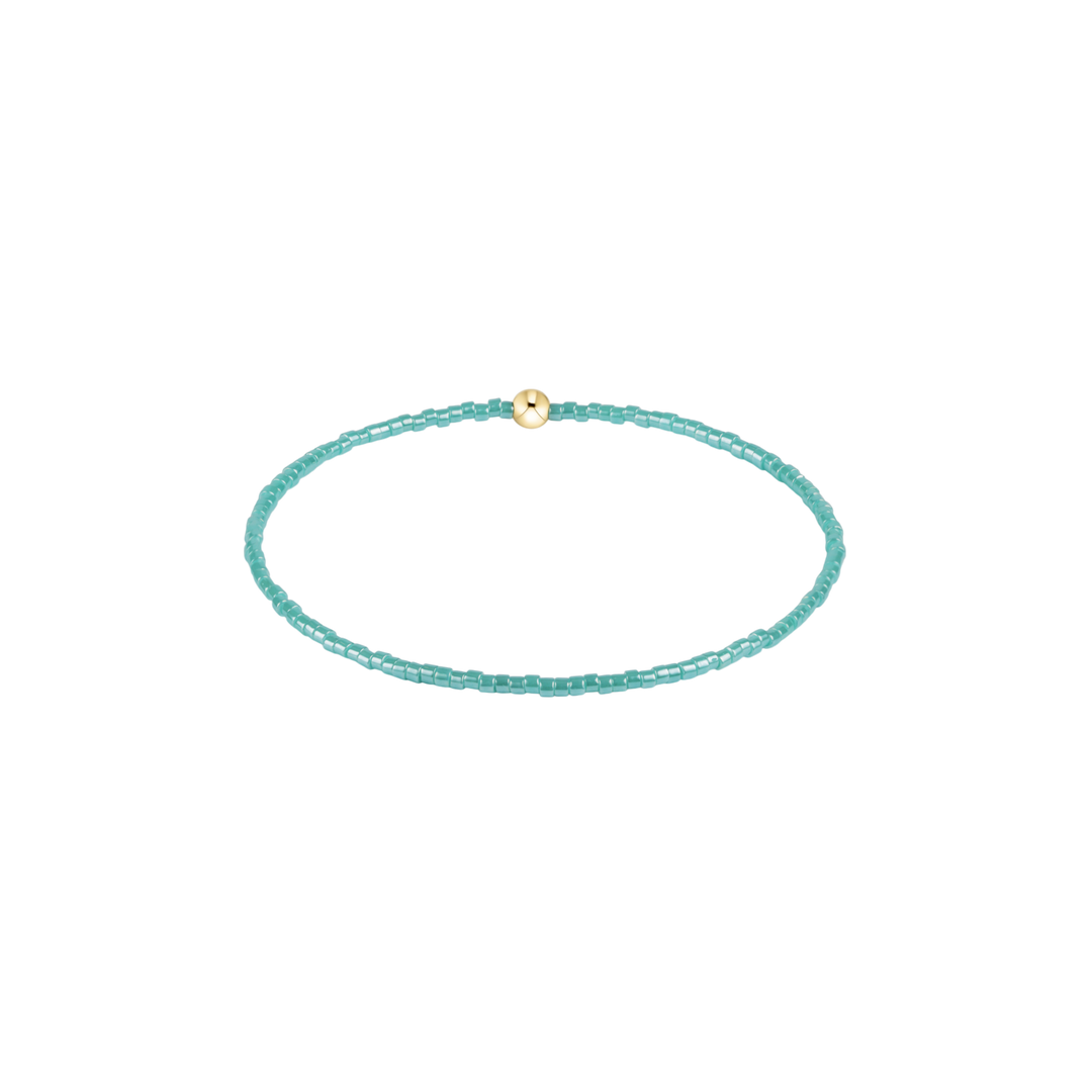 green blue beaded bracelet with gold accent bead