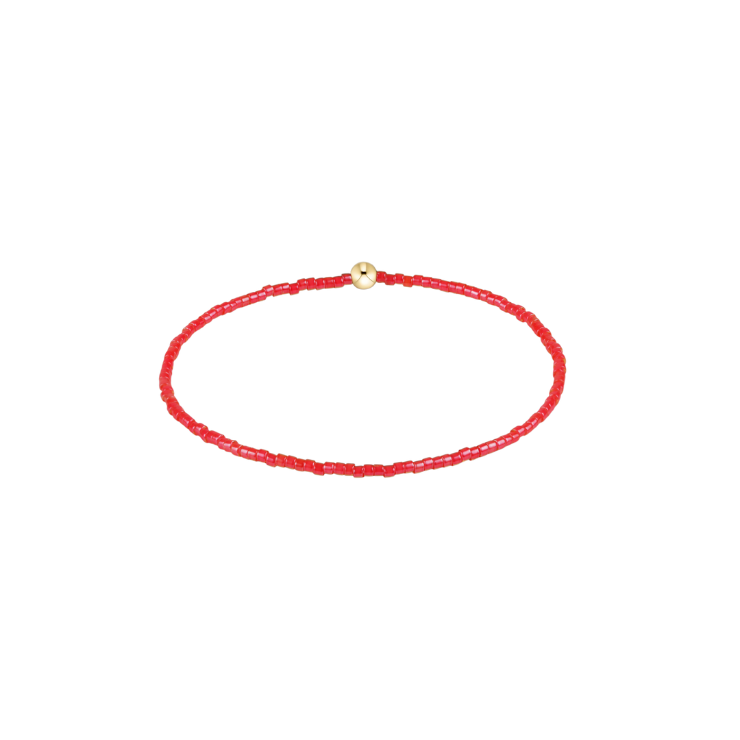 Red beaded bracelet with a gold clasp on a white background