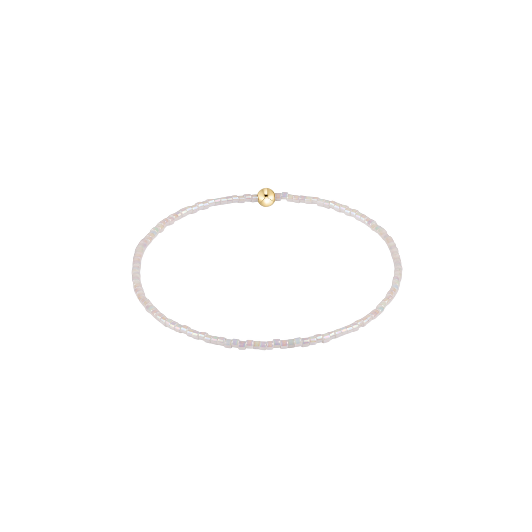 white beaded bracelet with gold accent bead