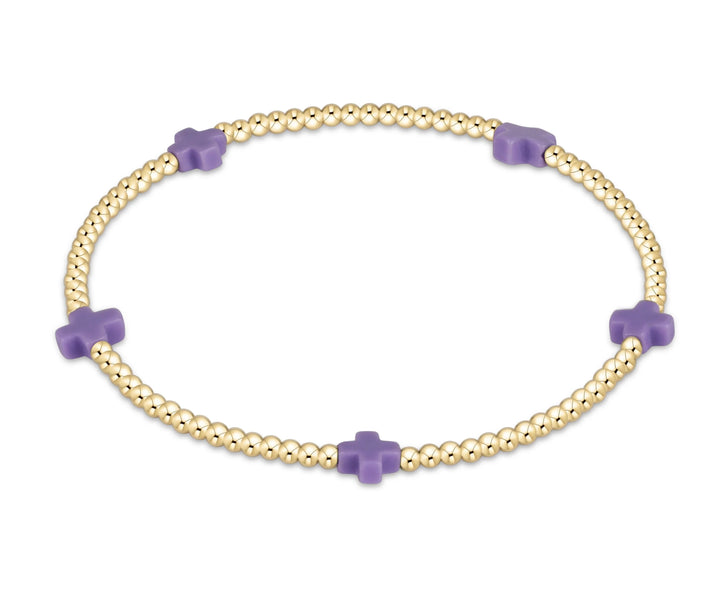 Gold bracelet with purple beads on a white background