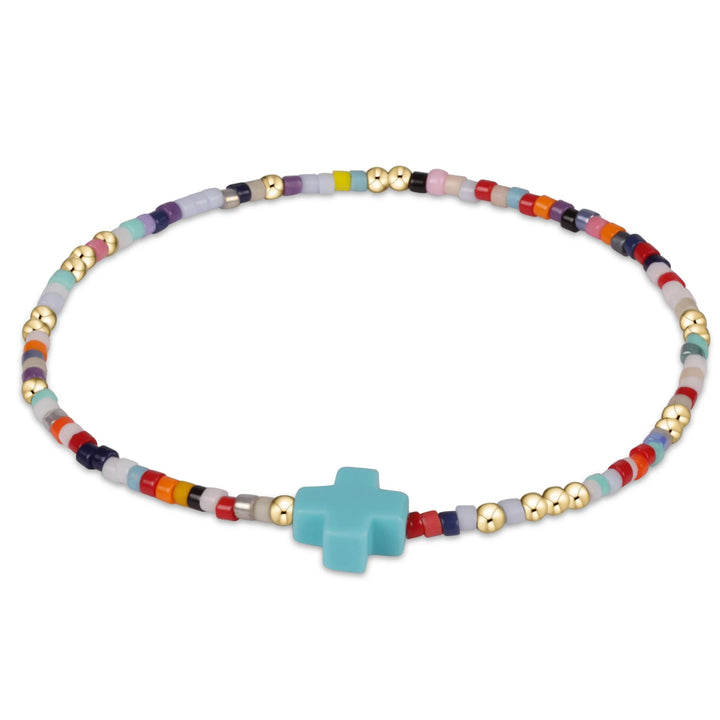 Colorful beaded bracelet with a turquoise cross pendant on a white background