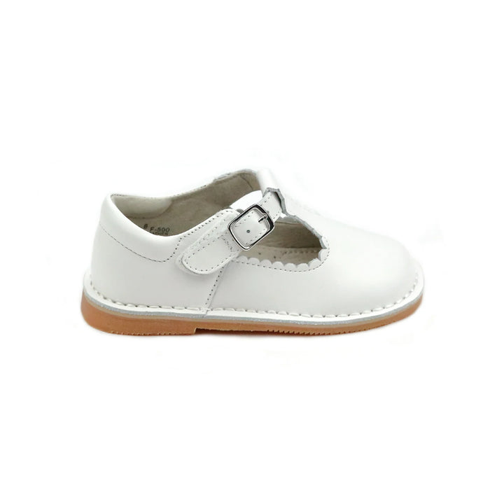 White child's shoe with a brown sole on a white background