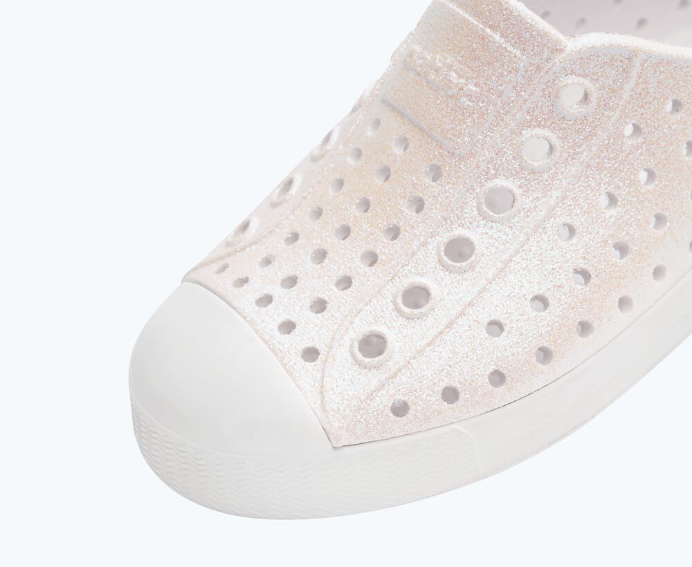Close-up of a white sneaker with holes on a light gray background