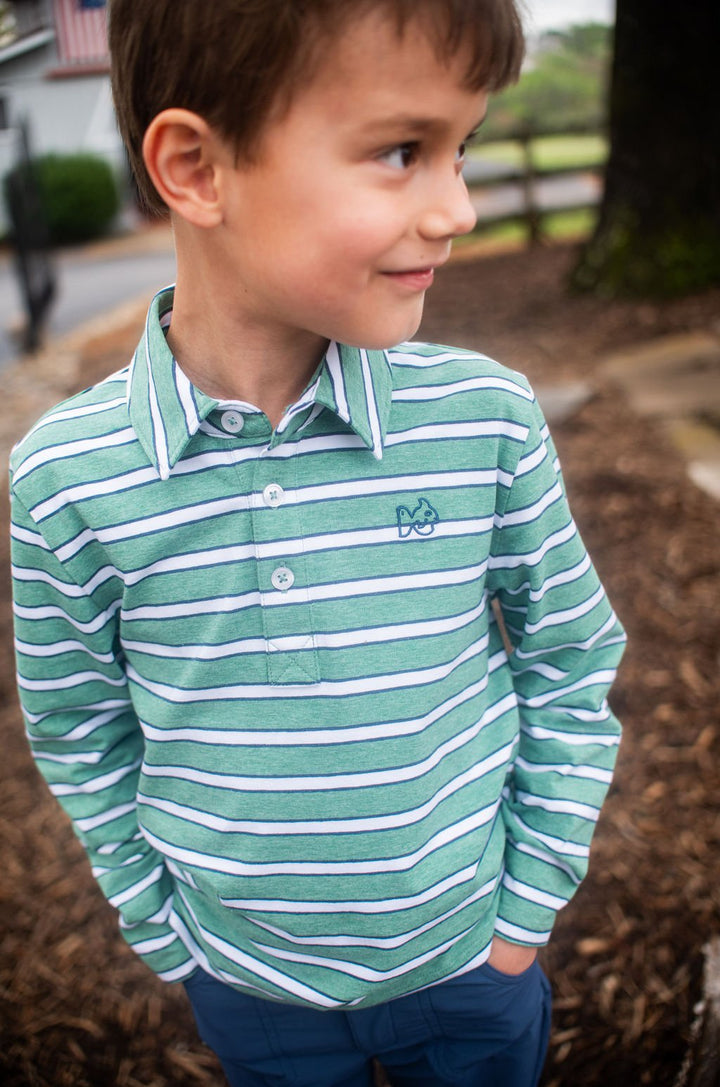 Young boy wearing a green and white striped shirt with a prodoh logo outdoors.