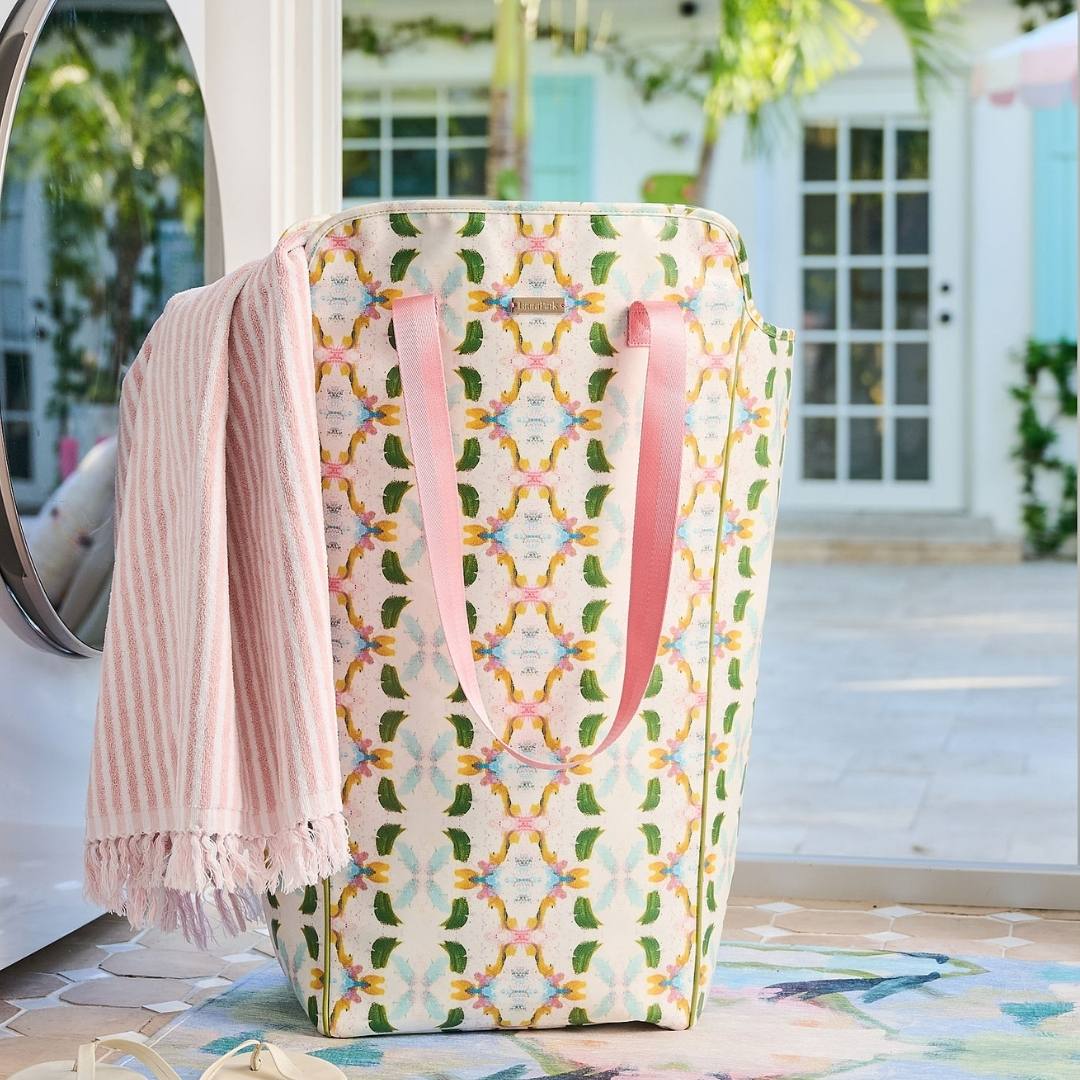 Patterned laundry basket with pink towel draped over it outdoors