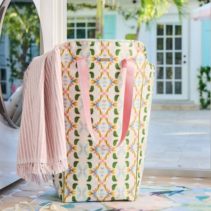 Patterned laundry basket with pink towel draped over it outdoors