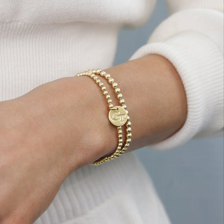 gold beaded bracelet with Georgia Tech charm on wrist - enewton