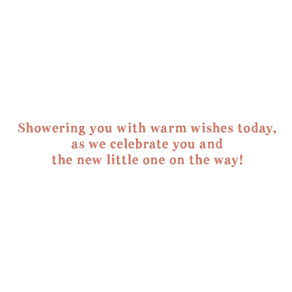 A square white card or print featuring centered coral-red text that reads, 'Showering you with warm wishes today, as we celebrate you and the new little one on the way!'.
