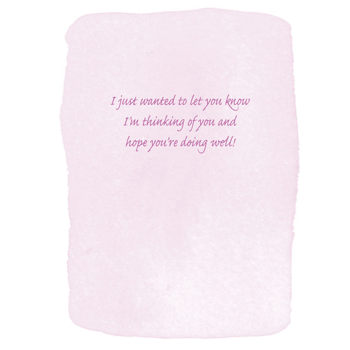 A square light pink textured card with hand-drawn rough edges and cursive purple text in the center reading, 'I just wanted to let you know I'm thinking of you and hope you're doing well!'.