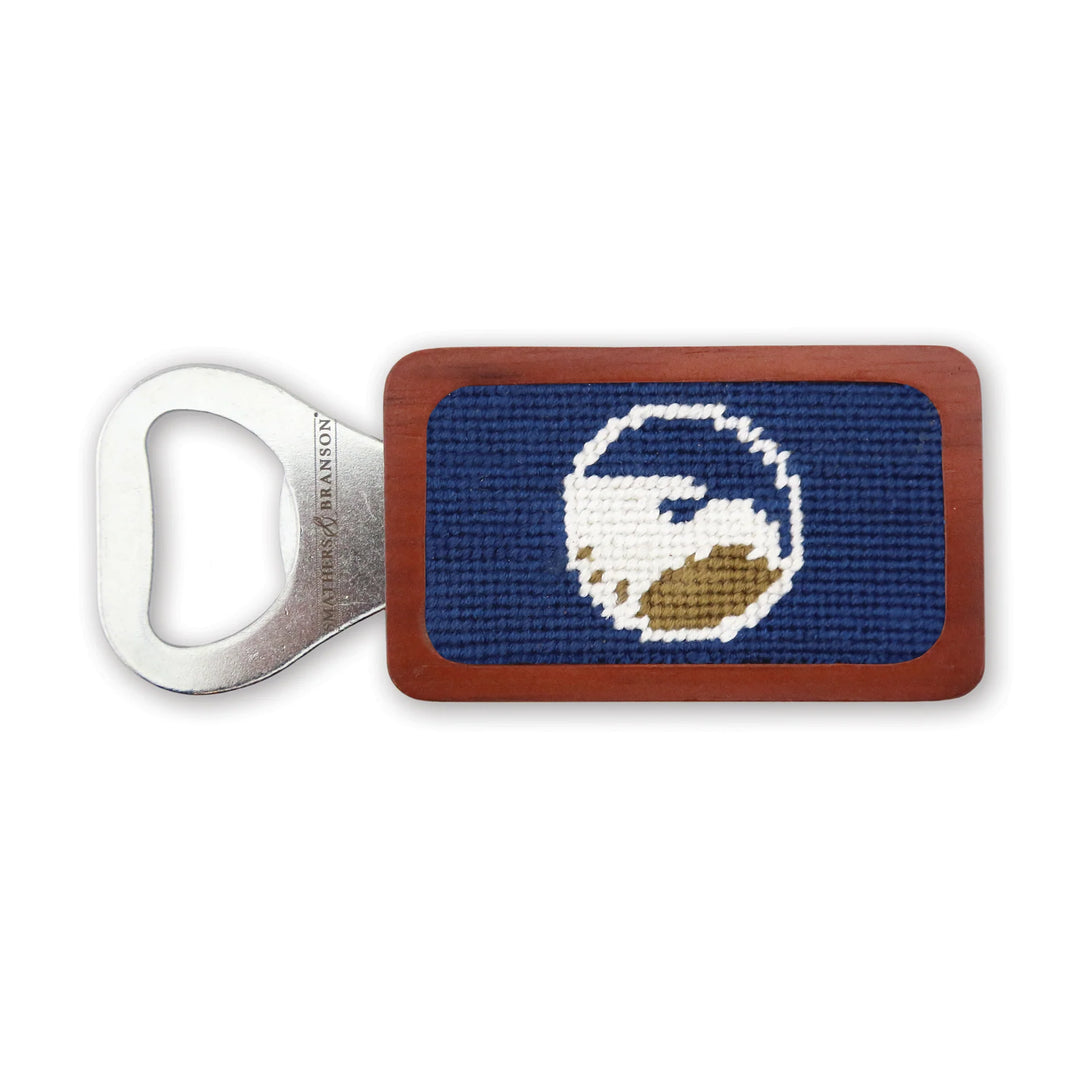 Bottle opener with needlepoint design on a white background
