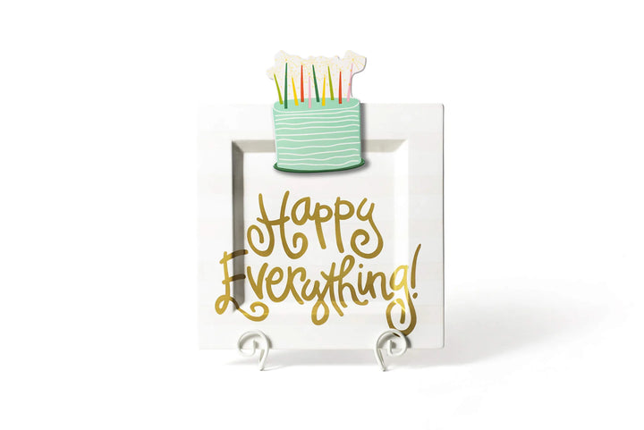 Decorative sign with 'Happy Everything!' text and a small cake model on a white background