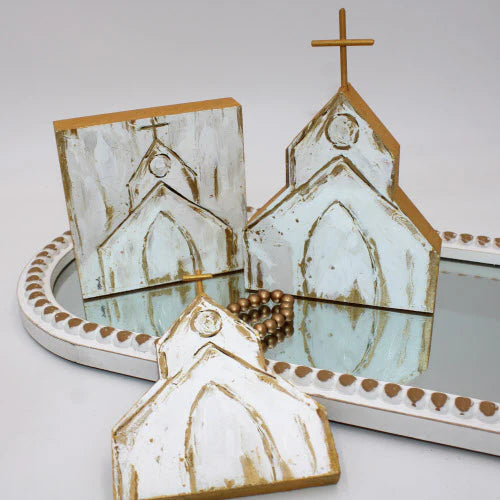 Decorative church-shaped items with gold accents on a white surface