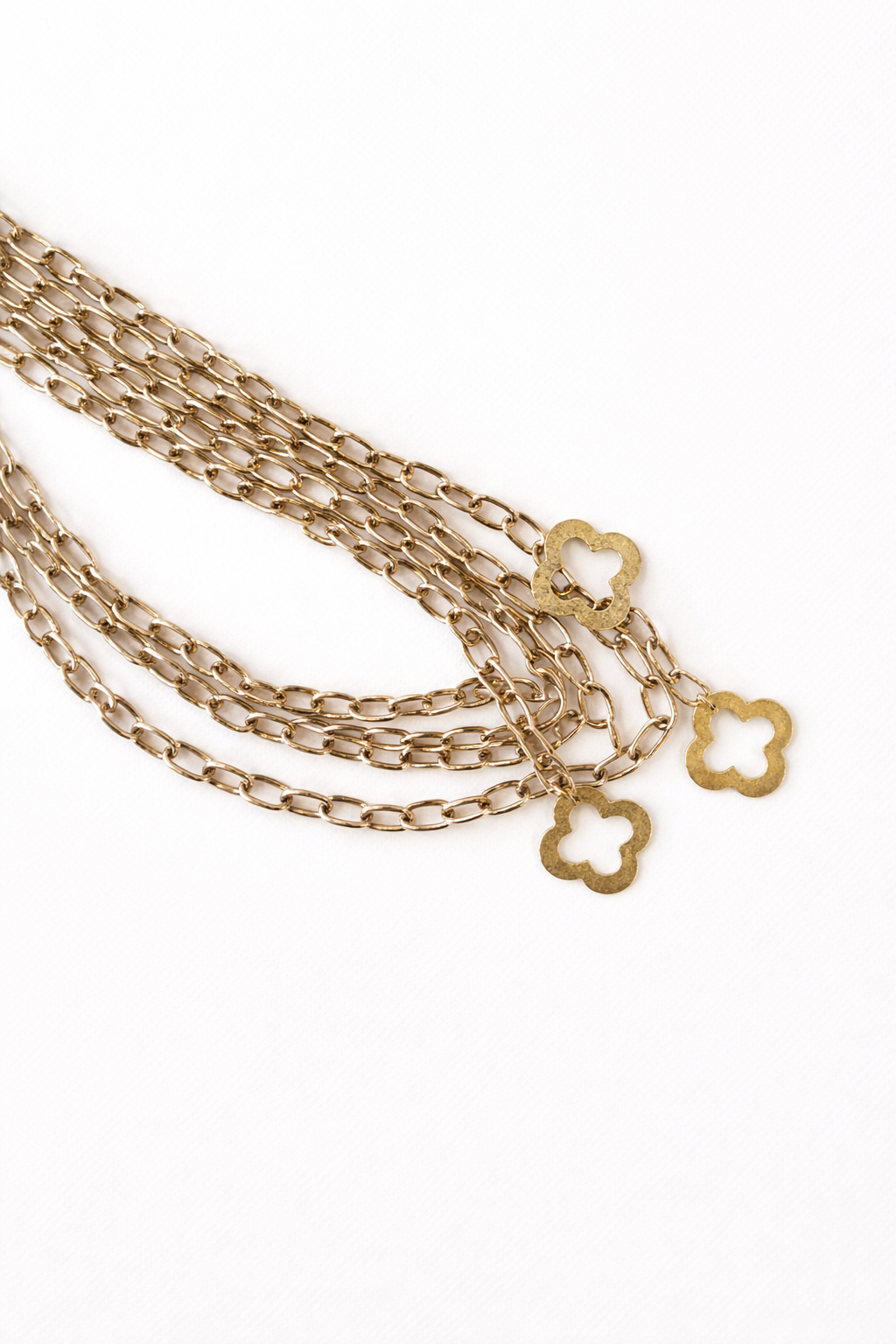 Gold chain necklace with star-shaped clasps on a white background