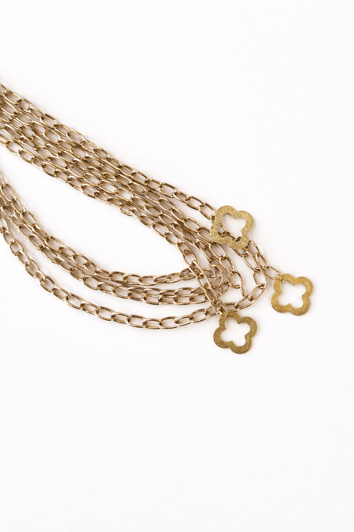 Gold chain necklace with star-shaped clasps on a white background